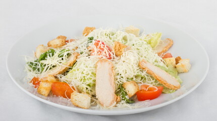 Caesar salad with chicken on a white plate