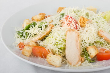Caesar salad with chicken on a white plate