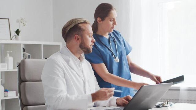 Professional medical doctors working in hospital office. Discussion with the chief physician and the young nurse.