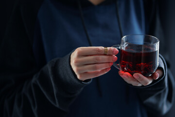 Cozy home. Female hands holding hot cup of tea.