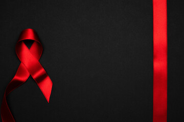 Aid ribbon silk. Red ribbon symbol in hiv world day on black background. Awareness aids and cancer....