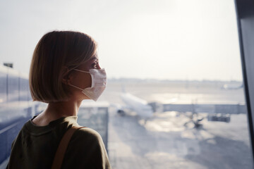 Fototapeta premium Woman wearing a face mask for prevent virus in international airport. Protection against Coronavirus.
