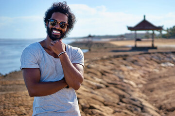 Handsome and confident. Outdoor portrait of smiling young african man on tha beach.