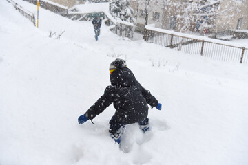 bambino che gioca nella neve nevicata montagna alta montagna grossa nevicata inverno divertimento 