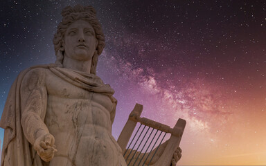 Apollo, the ancient Greek god illuminated by the starry night sky, Athens, Greece.