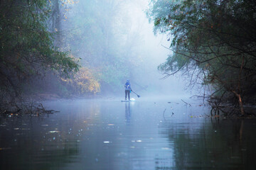 unrecognizable female with paddle swim on the sup board along the