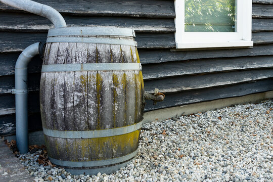 wooden water barrel with rain pipe
