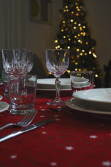 Elegant dining table with red tablecloth set for christmas dinner