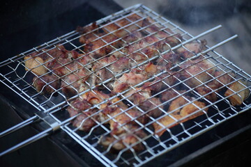 Tasty crisp mix meat barbecue on a metal grid in the grill closeup - outdoor kitchen, party, recreation, healthy food