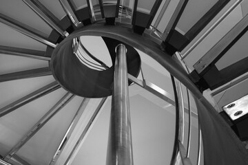 Detail of a spiral staircase made of aluminum and glass.