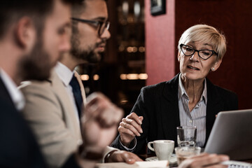 Business people holding a meeting at office cafeteria discussing about business plan.