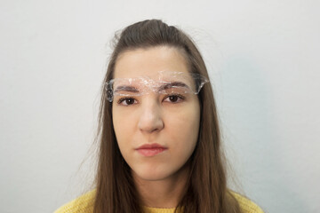 model's face in preparation for eyebrow dyeing. Beautiful girl looks into the camera.  Eyebrow...