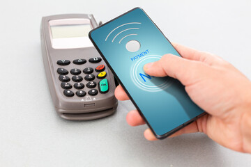 Man using NFC technology on smart phone to pay bill