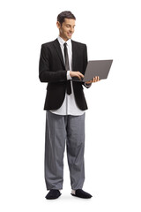 Young modern businessman in a suit and pajamas working on a laptop