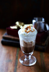 Coffee with whipped cream on dark wooden background. Close up. 