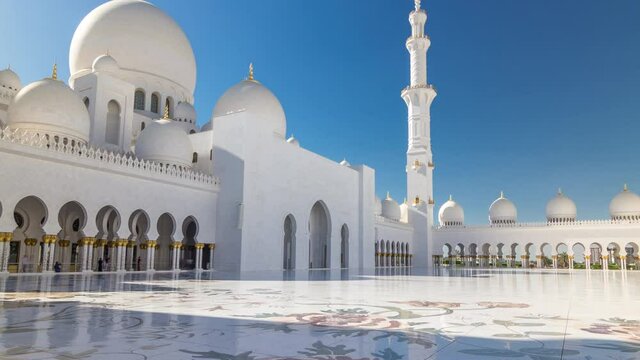 Sheikh Zayed Grand Mosque timelapse hyperlapse in Abu Dhabi, the capital city of United Arab Emirates. Inner court yard. Blue sky at sunny day