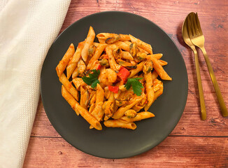 Seafood penne pasta, also know as pasta frutti di mare, in tomato sauce.