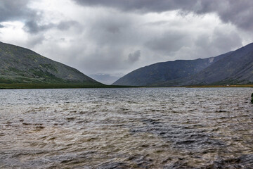 cold lake and mountain range on a rainy day