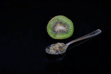 Ripe cut kiwi on the dark background