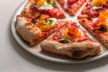 Close up of gourmet pizza slices with tomato, mozzarella, basil and crisp pepper skin. Ready-to-eat pizza