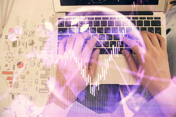 Double exposure of man's hands typing over laptop keyboard and forex chart hologram drawing. Top view. Financial markets concept.