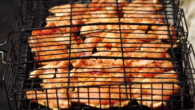 close-up of flattened out barbecued golden crispy skin chicken tabaka on grid, side view from above