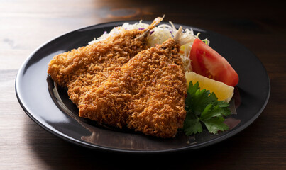 Fried horse mackerel served on a plate on a wooden background
