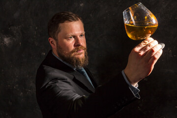 Solid confident bearded man in suit with glass of whisky