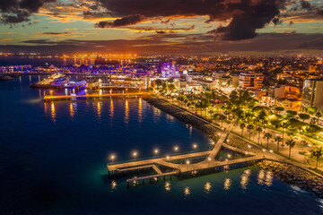 Republic of Cyprus. Panorama of evening Limassol from the air. The Mediterranean coast is lit up with lights. Travel to Cyprus. The coastline of Cyprus at night. Evening in Limassol.