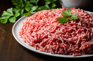 Minced meat served on a round plate on a wooden background