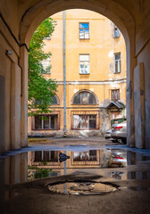 Fototapeta na wymiar View of the yard and house through the arch of the entrance in Saint-Petersburg, Russia