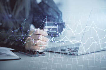 Multi exposure of woman on-line shopping holding a credit card and financial graph drawing. Stock market E-commerce concept.