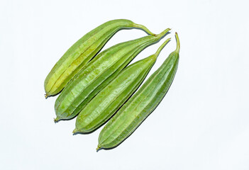 Fresh organic ridged gourd or angled luffa on white background.