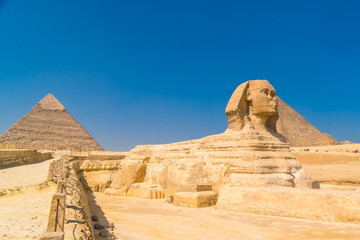 The Great Sphinx of Giza and in the background the Pyramids of Giza one summer afternoon, the...