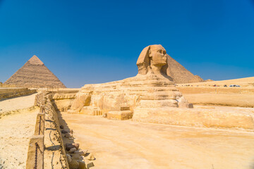 The Great Sphinx of Giza and in the background the Pyramids of Giza, the oldest Funerary monument in the world. In the city of Cairo, Egypt