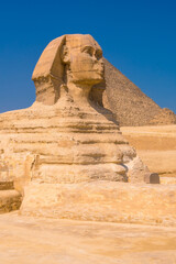 The Great Sphinx of Giza and in the background the Pyramids of Giza, the oldest Funerary monument in the world. In the city of Cairo, Egypt. Vertical photo