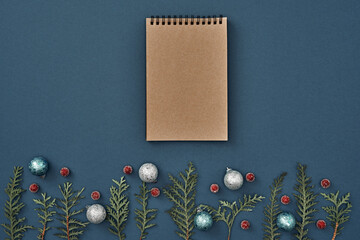New Year's decor and a notebook in the center on a blue background. Christmas decoration. Copy space, flat lay, mock up, top view.