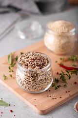 red and white dry quinoa in a glass jar