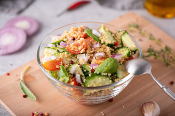 fresh vegetable and quinoa salad in a glass bowl on the table