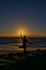 Fototapeta premium Woman Practicing Yoga at Sunset on a Maui Beach