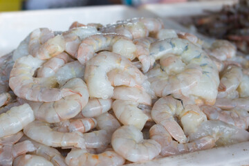 Fresh prawns without the head on a tray in the fish market. Food very widespread in coastal cities.Raw Shrimp.Fresh shelled prawns on the fish market. close-up photo of ocean food.  Fish Food.