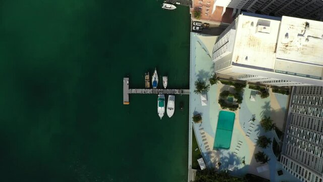 Miami Beach condo scene aerial video facing down pools on the bay