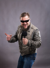 Fototapeta premium Bearded emotional rock singer with microphone studio portrait.