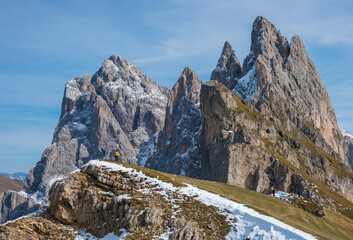 Man alone in the distance looking at mountains Odle in Seceda 