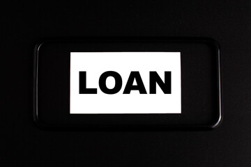 the word LOAN in a black frame on a black background.The concept of Loan