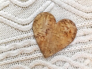 wooden heart on a white sweater. DIY wooden heart on a beautiful sweater background