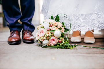 Blumenstrauss vor den Füssen des brautpaares