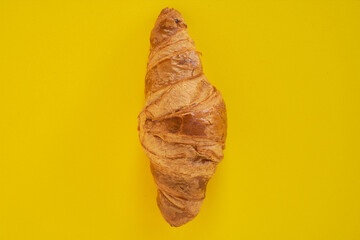 Croissant on yellow background. Minimalist sweet photo. copy space