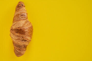 Croissant on yellow background. Minimalist sweet photo. copy space
