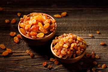 Raisins in bowls on a rustic wooden table close up view